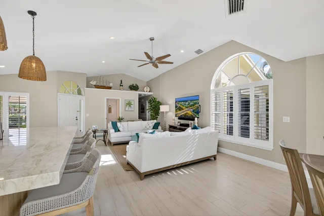 a living room with furniture a chandelier and a large window