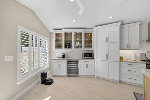 a kitchen with white cabinets and window