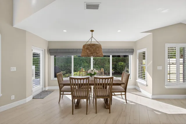 a dining room with furniture window and wooden floor