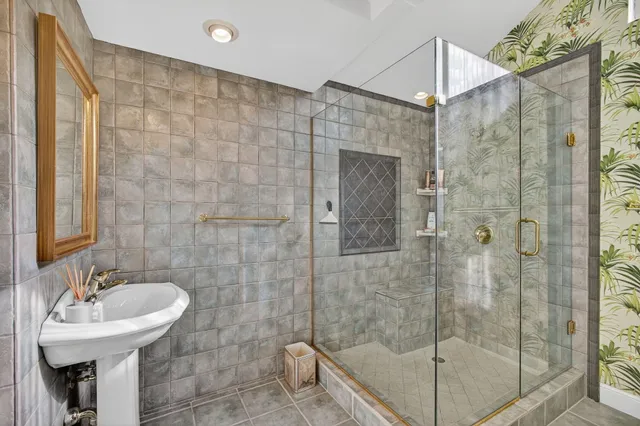 a bathroom with a sink shower and a mirror