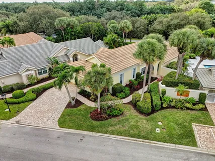 an aerial view of a house with yard and greenery