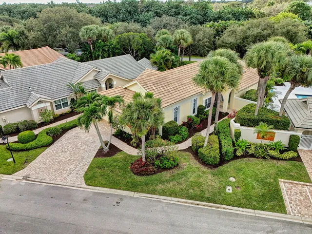 an aerial view of a house with yard and greenery