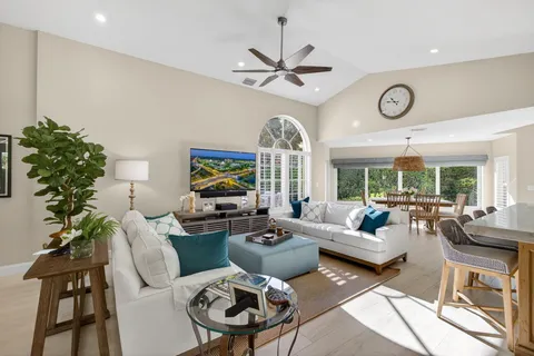 a living room with furniture a chandelier and a large window