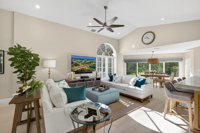 a living room with furniture a chandelier and a large window