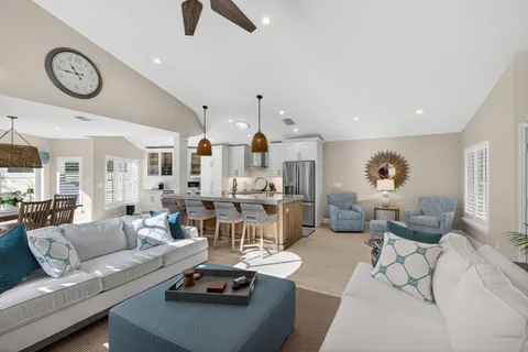 a living room with furniture kitchen view and a chandelier