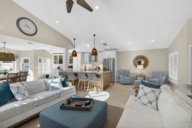 a living room with furniture kitchen view and a chandelier