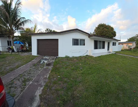 a front view of house with yard and trees in the background