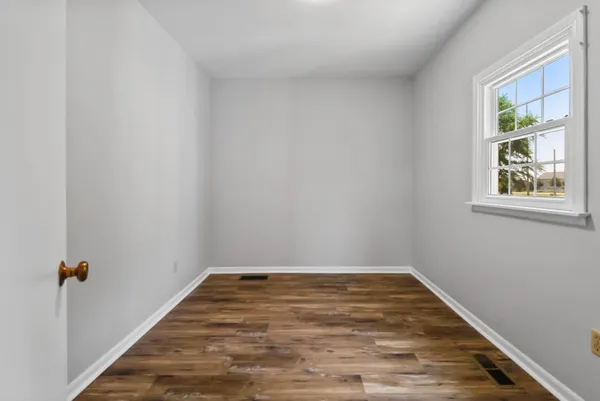 a view of empty room with wooden floor