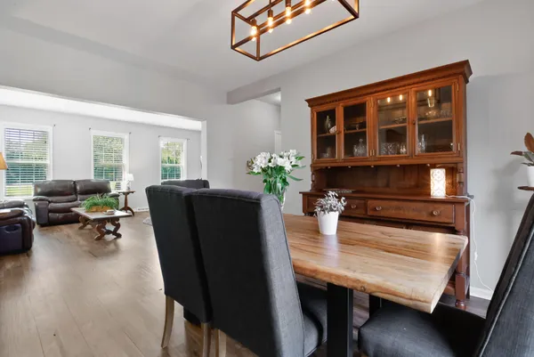 a living room with furniture dining table and wooden floor