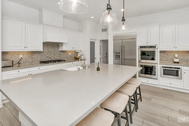 a kitchen with stainless steel appliances a sink a stove and cabinets