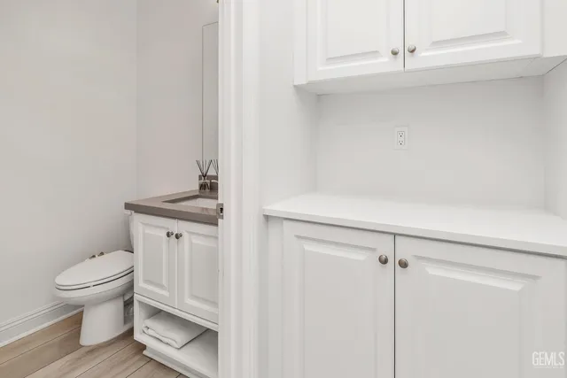 a spacious bathroom with a granite countertop sink a toilet a mirror and shower