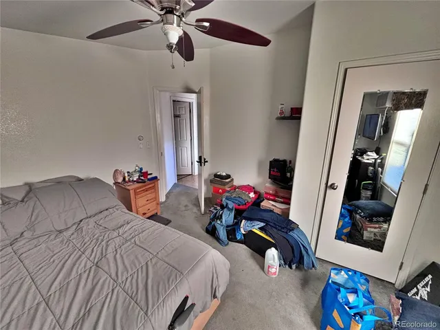 a bedroom with bed and a mirror