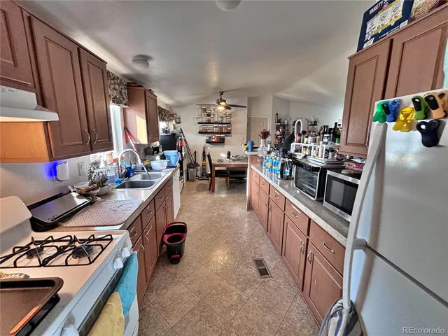 a white kitchen with refrigerator and sink