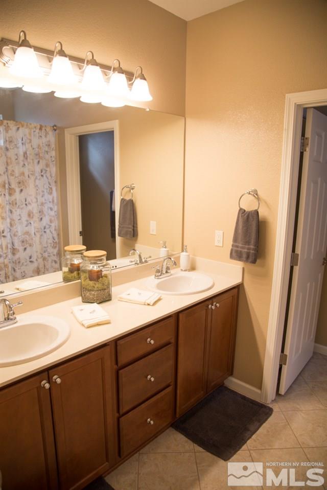 11061 Colton Drive Reno, NV 89521 - Photo 17 of 24 a bathroom with a double vanity sink and a mirror