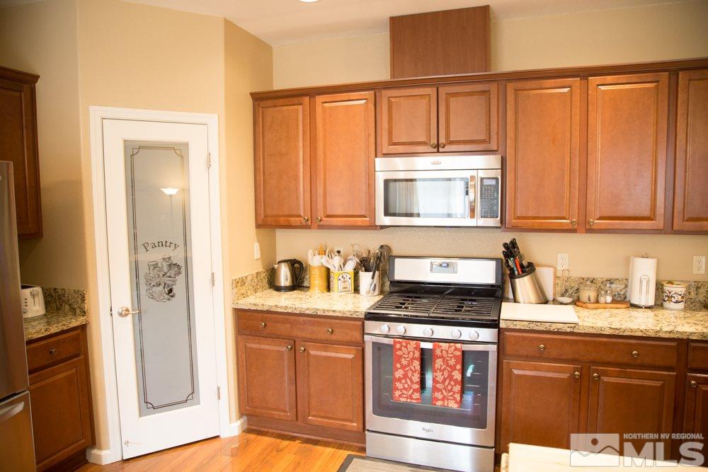 11061 Colton Drive Reno, NV 89521 - Photo 5 of 24 a kitchen with stainless steel appliances granite countertop a refrigerator stove and sink