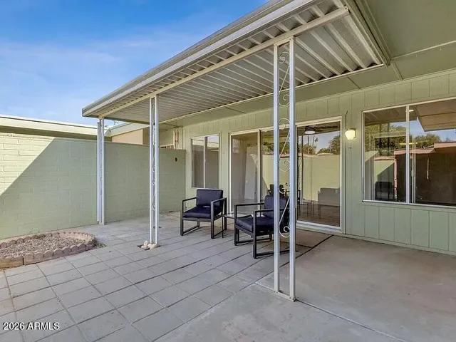 a backyard of a house with table and chairs
