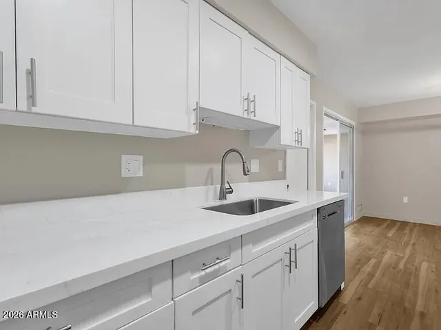 a kitchen with white cabinets and sink
