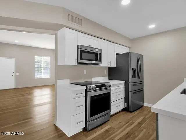a kitchen with stainless steel appliances a stove microwave and refrigerator