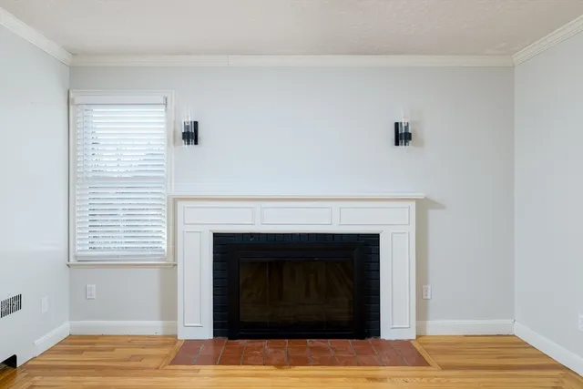 a living room with a fireplace and wooden floor