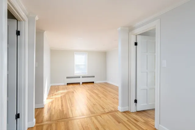 a view of a bedroom with wooden floor and bathroom
