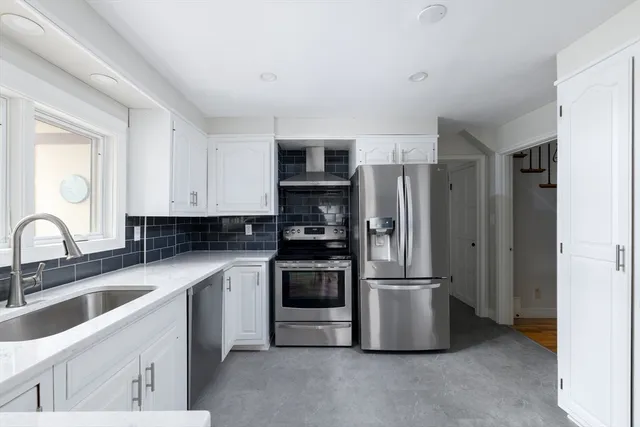 a kitchen with stainless steel appliances granite countertop a refrigerator stove and sink