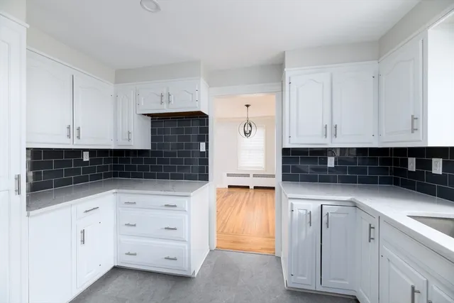 a kitchen with granite countertop white cabinets and sink