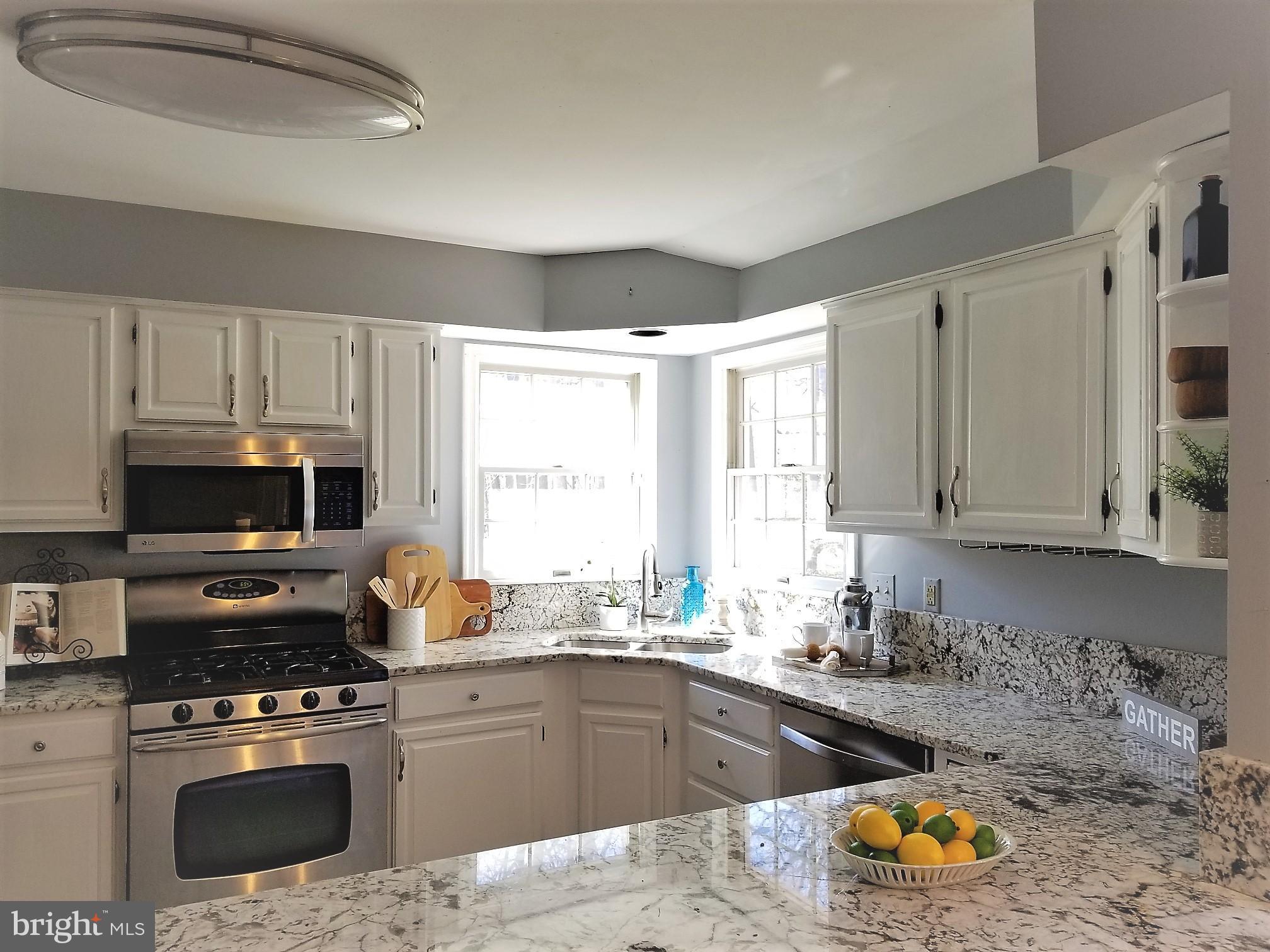 1404 Hunting Wood Road Annapolis, MD 21403 - Photo 2 of 15 a kitchen with a sink a stove a microwave and wooden cabinets