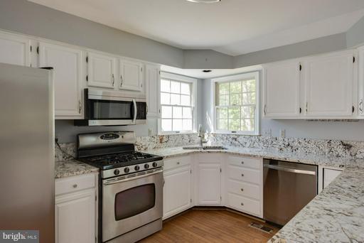 1404 Hunting Wood Road Annapolis, MD 21403 - Photo 3 of 15 a kitchen with granite countertop white cabinets appliances a sink and a window