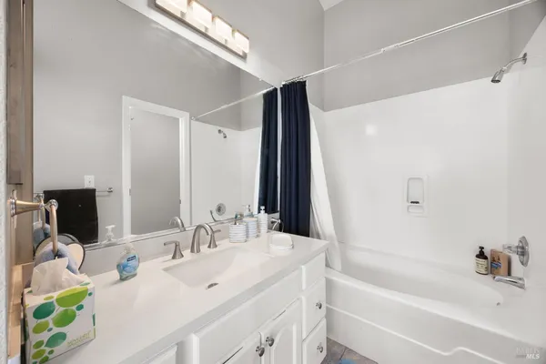 a bathroom with a bathtub sink and mirror