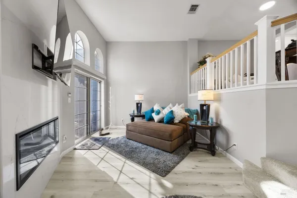 a living room with furniture a fireplace and a flat screen tv