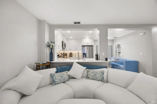 a living room with furniture and a large mirror with wooden floor