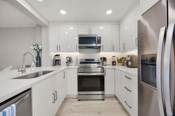 a kitchen with stainless steel appliances granite countertop a refrigerator sink and stove