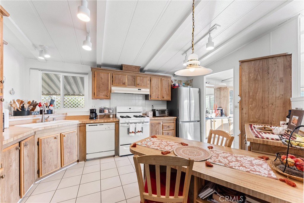 692 North Adele, Unit 64 Orange, CA 92867 - Photo 8 of 16 a kitchen with stainless steel appliances granite countertop a stove a refrigerator a sink dishwasher and white cabinets with wooden floor