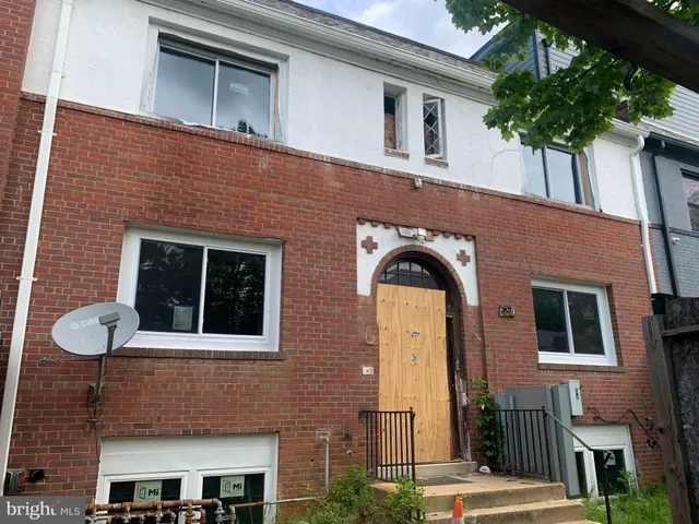 a front view of a house with plants