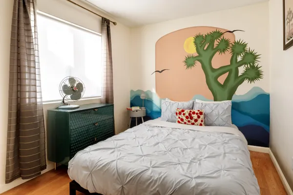 a bedroom with a bed and a painting on the wall