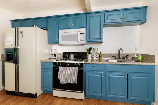 a kitchen with stainless steel appliances granite countertop a refrigerator and a stove
