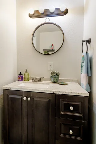 a bathroom with a granite countertop double vanity and a sink