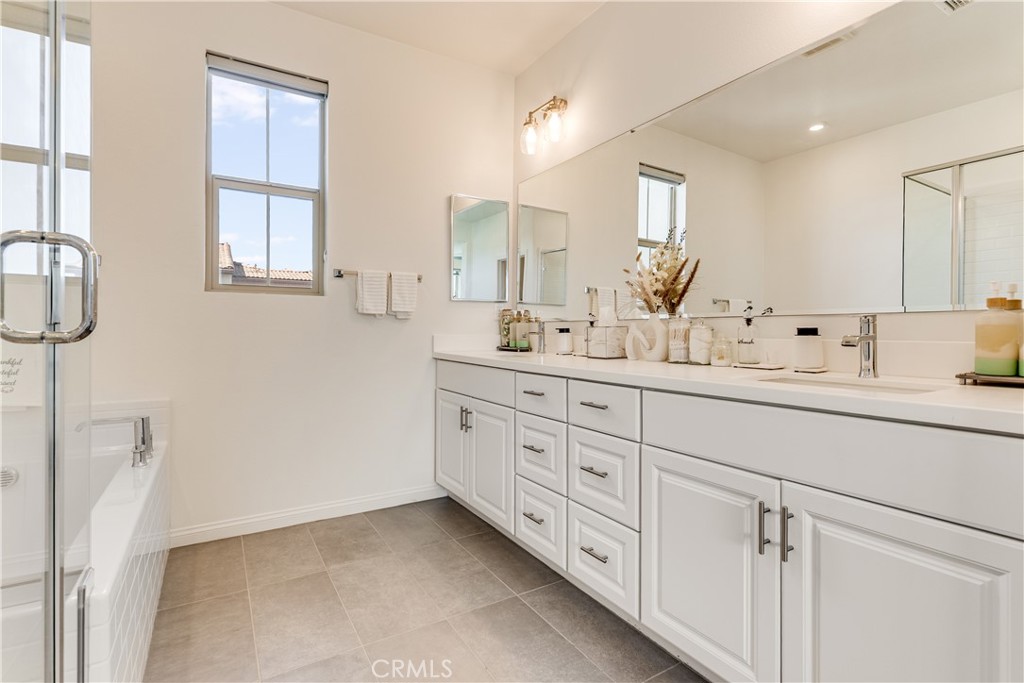 1648 Fig Tree Way Oceanside, CA 92056 - Photo 42 of 45 a spacious bathroom with double sink a mirror a window and a shower