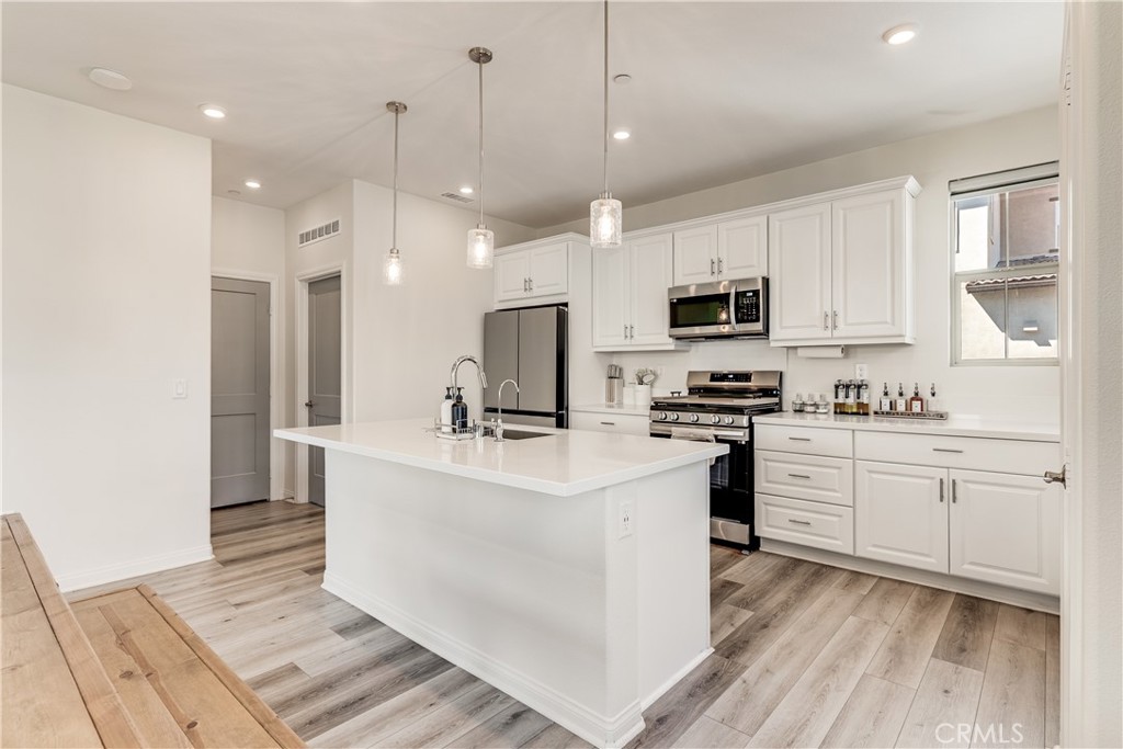 1648 Fig Tree Way Oceanside, CA 92056 - Photo 10 of 45 a kitchen with white cabinets and stainless steel appliances