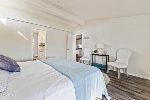 a bedroom with a bed a chair and dresser