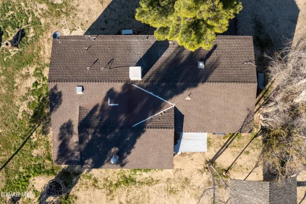 an aerial view of a house with a yard and large trees