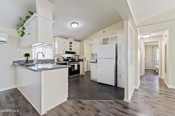 a kitchen with a refrigerator a stove top oven and white cabinets