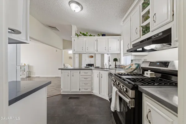 a kitchen with white cabinets and appliances