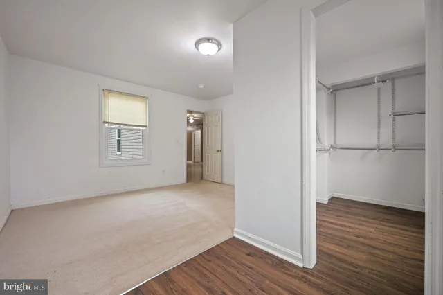 an empty room with wooden floor and closet