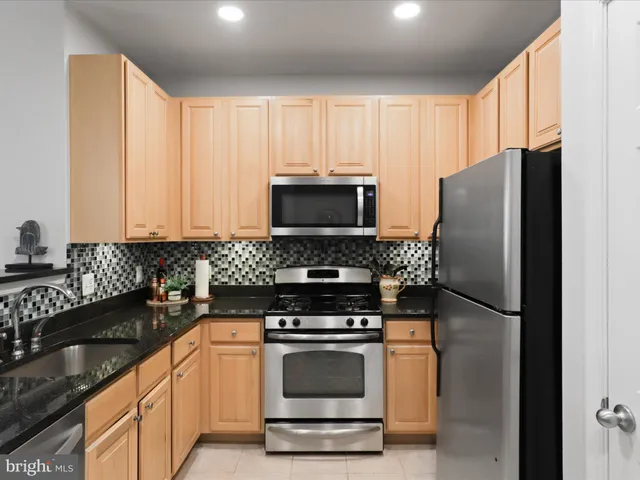 a kitchen with granite countertop a refrigerator stove and microwave