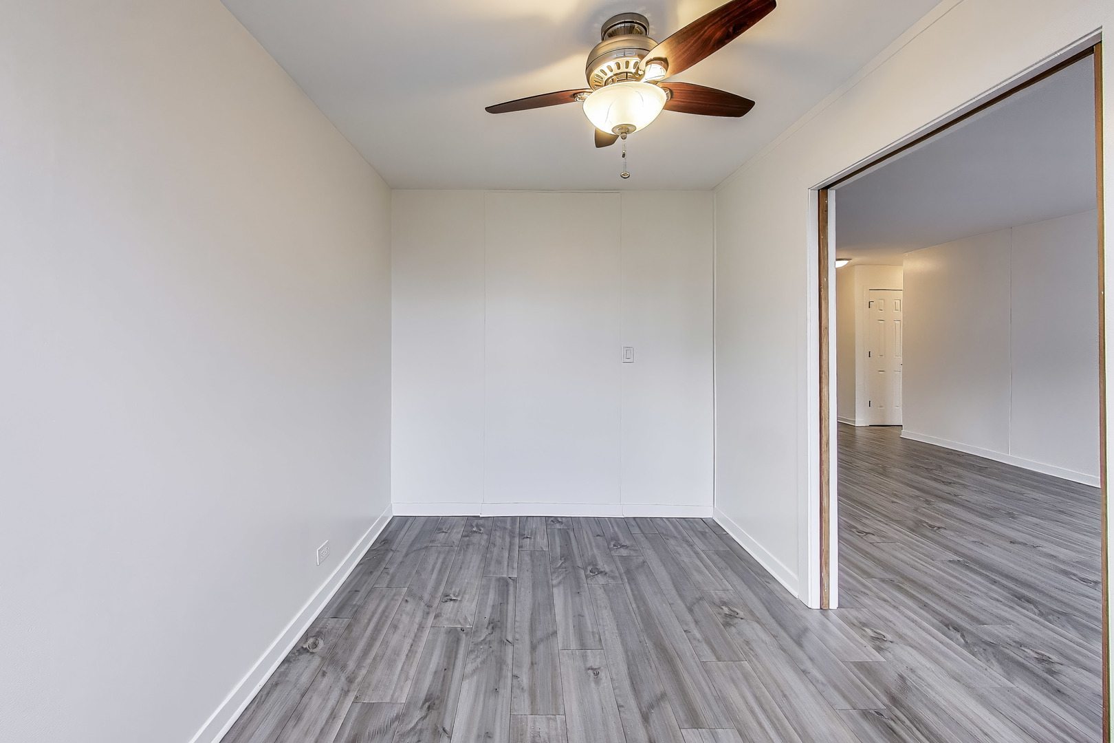 655 West Irving Park Road, Unit 606 Chicago, IL 60613 - Photo 13 of 28 a view of a room with wooden floor a ceiling fan and window
