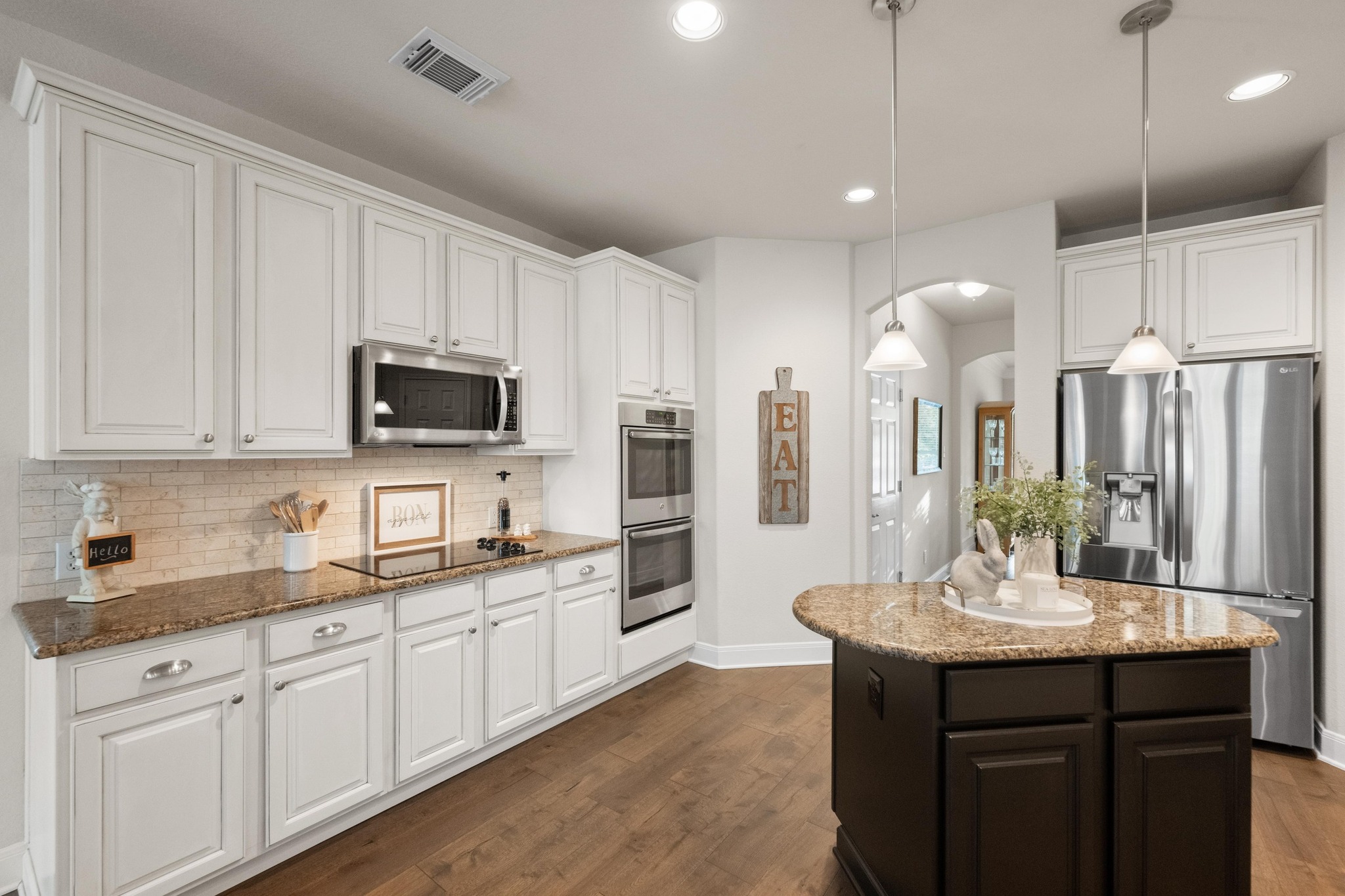 3713 Soledad Court Austin, TX 78732 - Photo 12 of 40 a kitchen with stainless steel appliances kitchen island granite countertop a sink a stove a microwave a counter space and cabinets