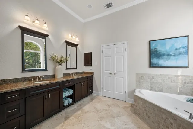 a spacious bathroom with a tub sink and mirror