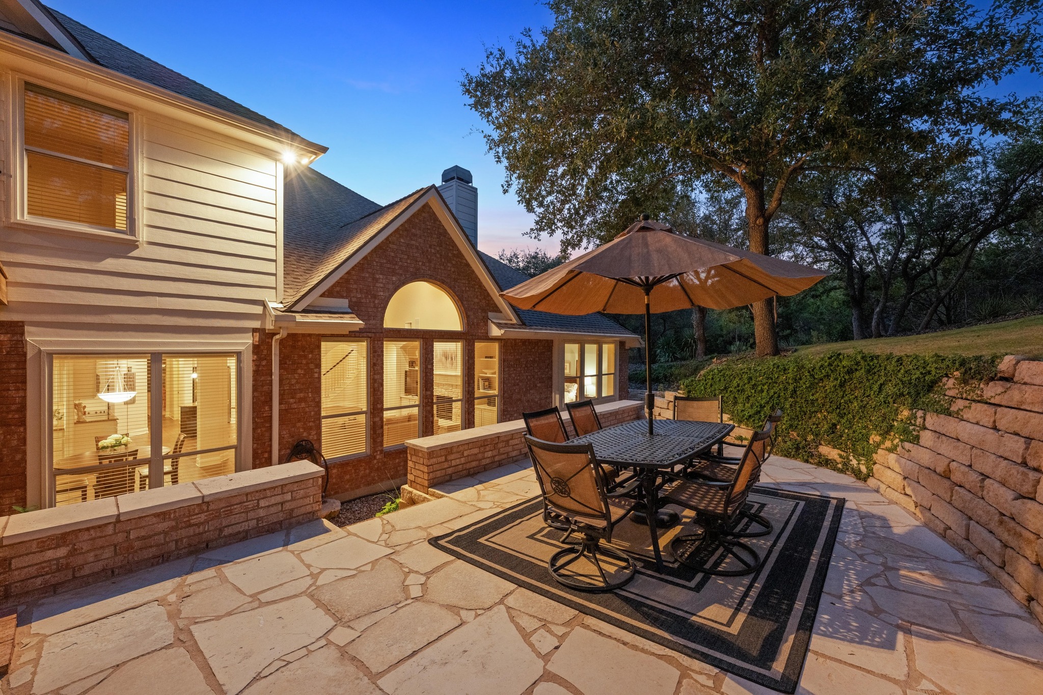 3713 Soledad Court Austin, TX 78732 - Photo 33 of 40 a patio with a table and chairs under an umbrella