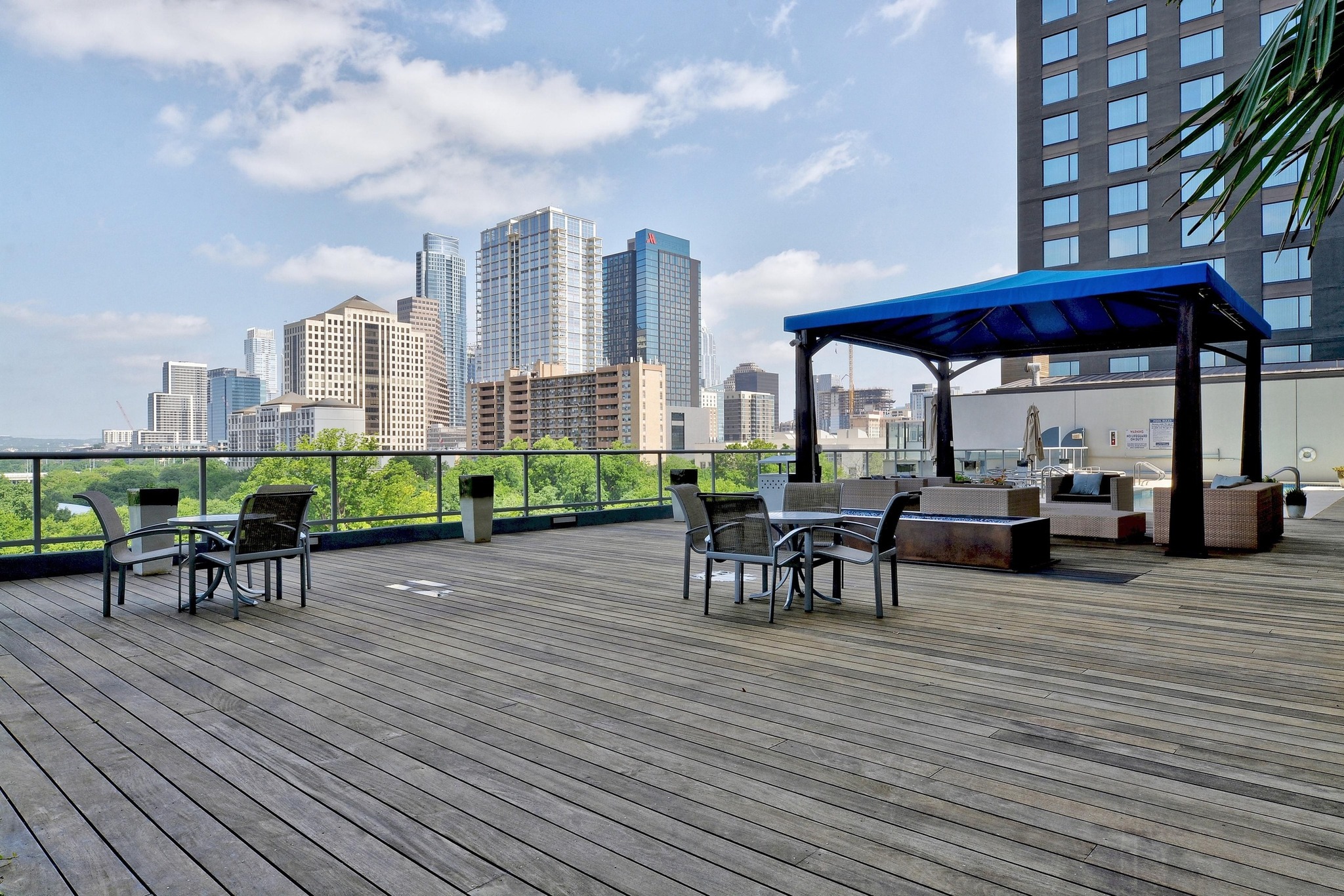 603 Davis Street, Unit 1002 Austin, TX 78701 - Photo 36 of 40 a view of a roof deck with table and chairs under an umbrella with wooden floor